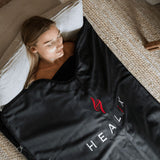 HEALiX-Z Sauna Blanket in use in a home environment, demonstrating its effectiveness in a cozy, ambient setting