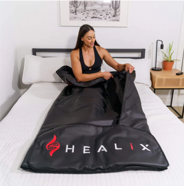 In Use: Person lying comfortably on the HEALiX Sauna Blanket, demonstrating its use for relaxation and wellness.