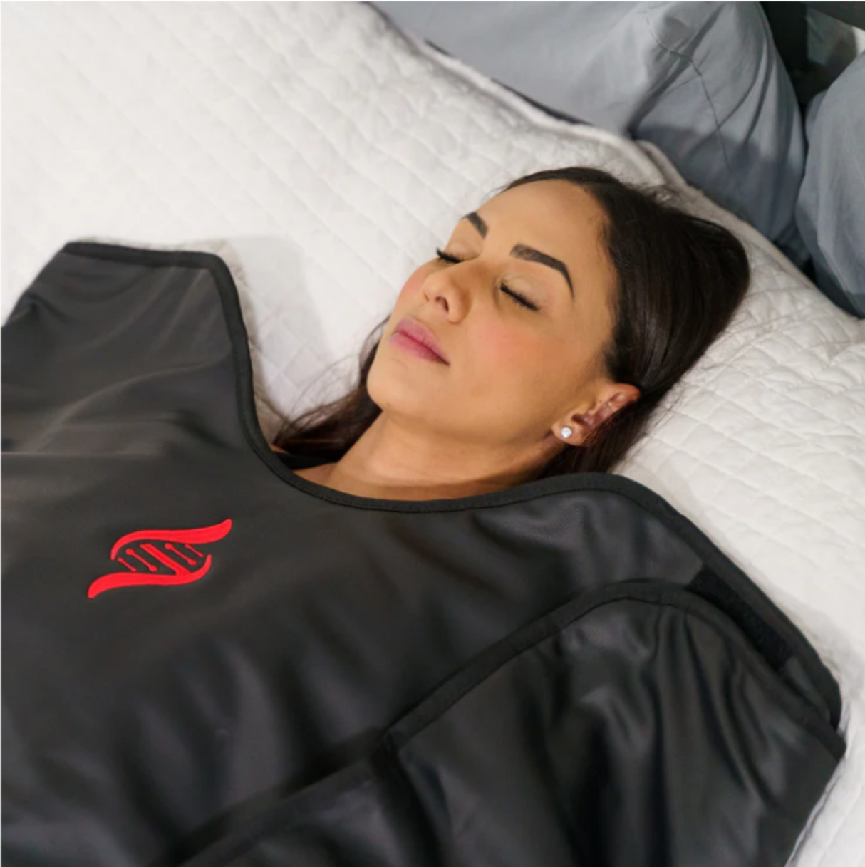 Person lying comfortably on the HEALiX Sauna Blanket, demonstrating its use for relaxation and wellness.