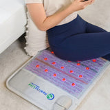 User experiencing relaxation on the HealthyLine Platinum Mat™ with visible gemstones.