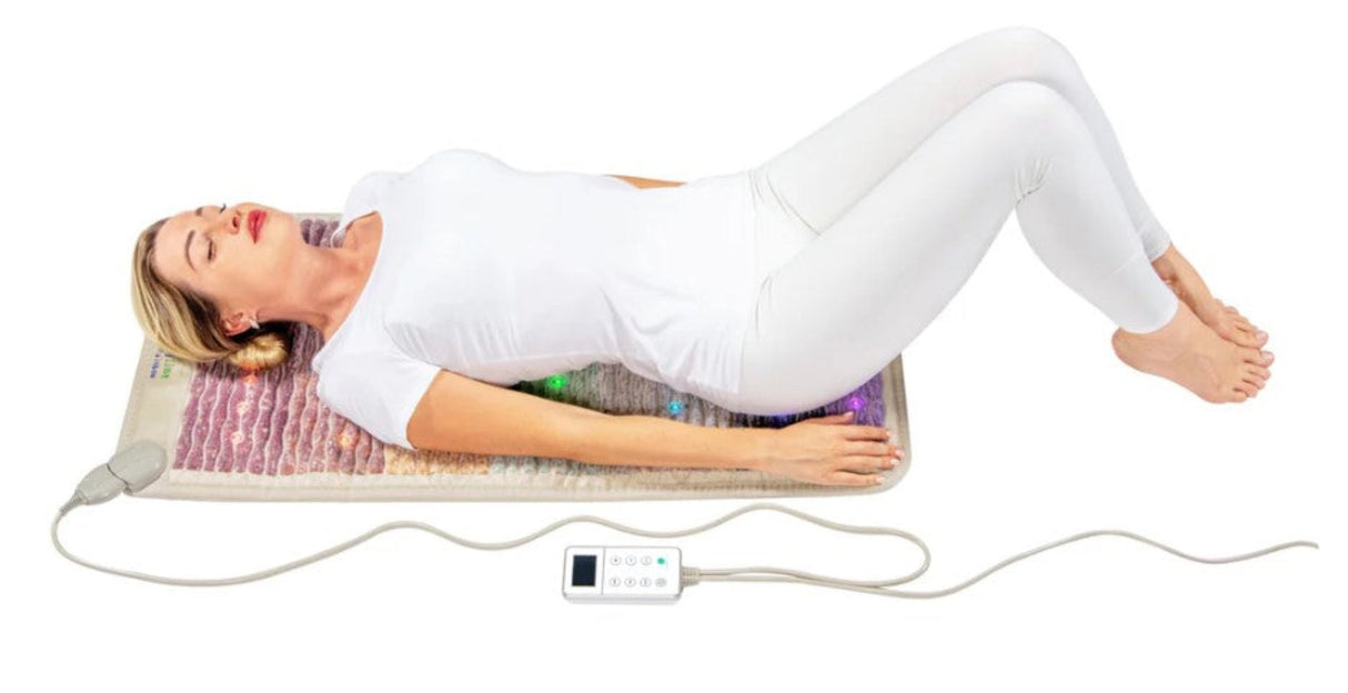 Person lying on the Healthy Line Rainbow Chakra Mat 4020, experiencing PEMF and photon therapy