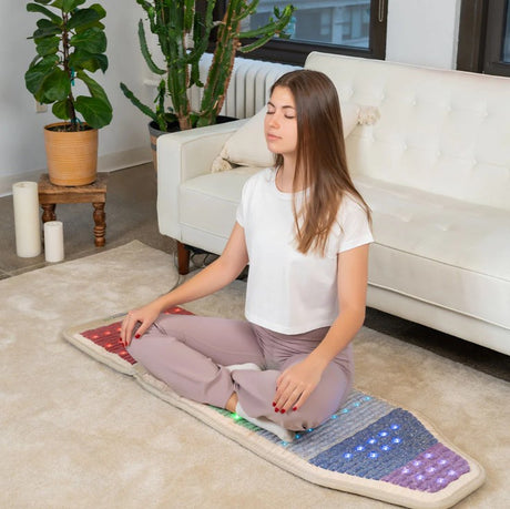 In-Use Image: "Person comfortably seated on the HealthyLine Rainbow Chakra Mat™ Chair 5718, enjoying the benefits of gemstone therapy and relaxation.