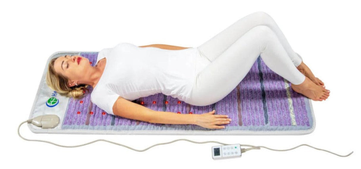 A person lying comfortably on the Healthy Line Platinum Mat™ 6024 Firm, enjoying a wellness session