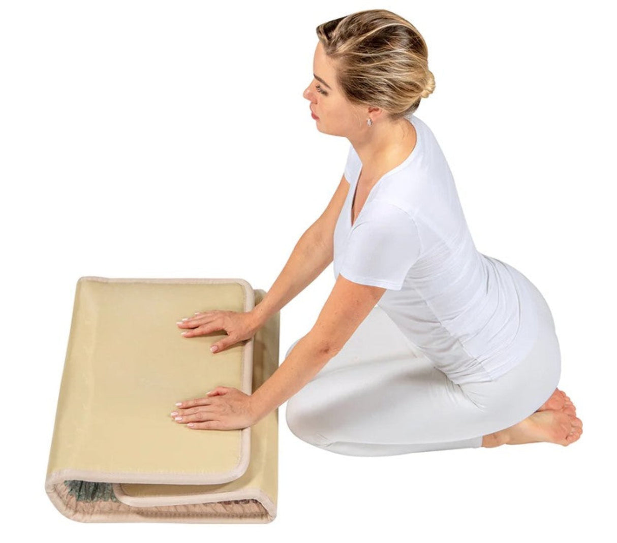 An individual demonstrating how to easily fold the Rainbow Chakra Mat for convenient storage.