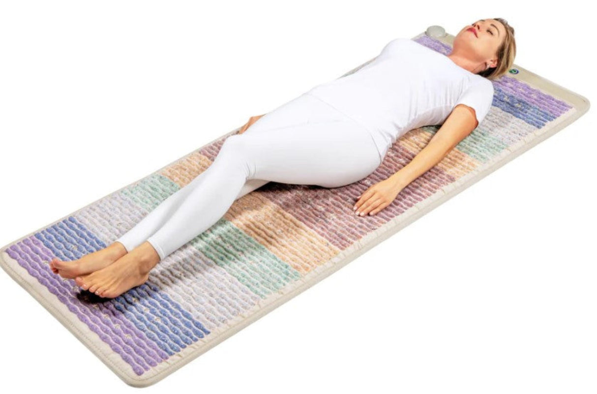  A person lying comfortably on the mat, surrounded by a calming environment, showcasing relaxation and wellness.