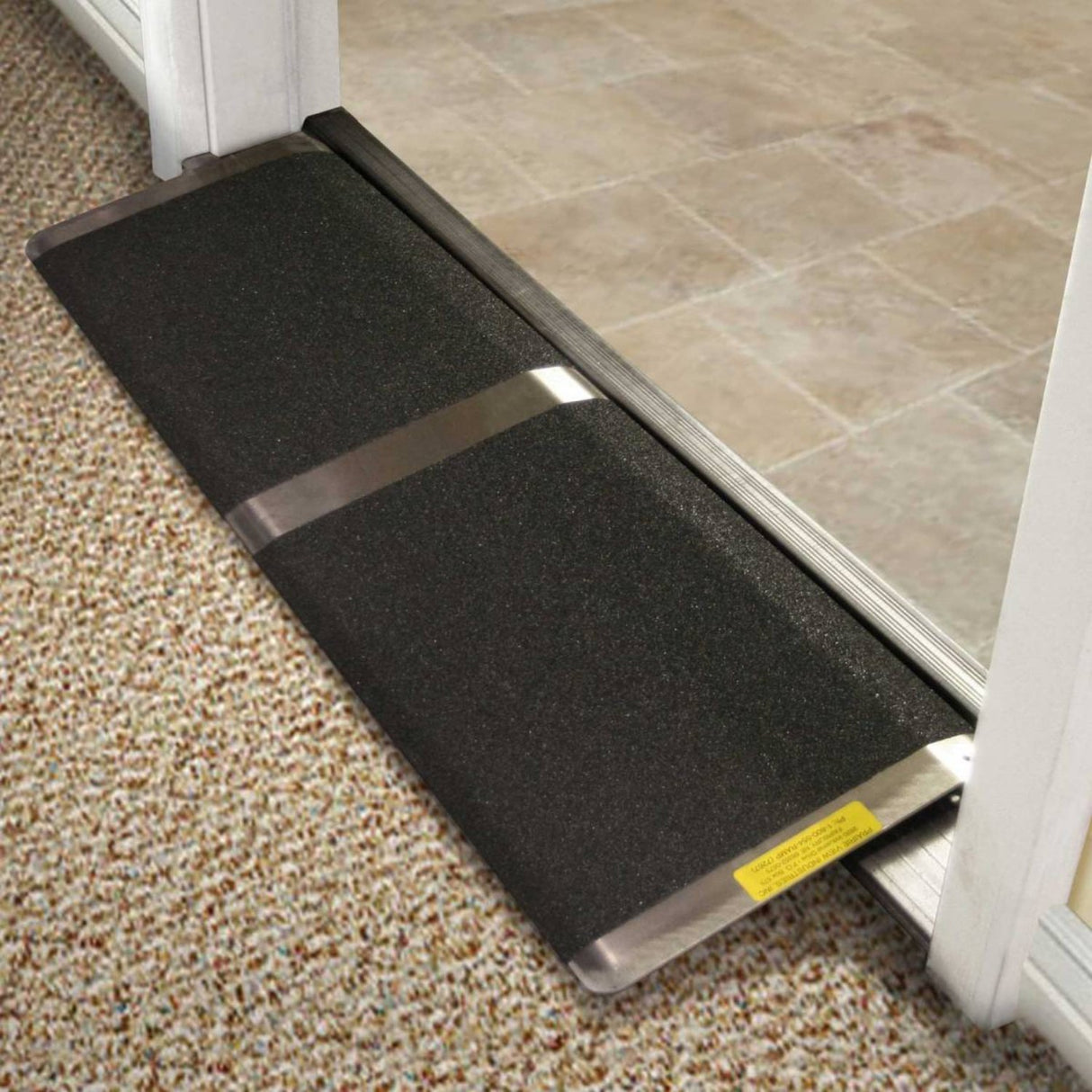 PVI Standard Threshold Ramp placed next to a open door, illustrating its compatibility with inward-swinging doors.